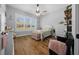 Cozy bedroom with a large window, hardwood floors, a ceiling fan, and lots of natural light at 11707 Se 101St Court Rd, Belleview, FL 34420