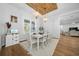 Bright dining room with a white table, chairs, chandelier, and wood paneled ceiling at 11707 Se 101St Court Rd, Belleview, FL 34420