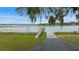 Scenic view of the dock leading into the lake, complemented by lush greenery and a clear blue sky at 11707 Se 101St Court Rd, Belleview, FL 34420