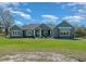 Beautifully landscaped home featuring a gray exterior and a well-manicured lawn at 11707 Se 101St Court Rd, Belleview, FL 34420