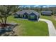 Stunning single-story home with gray siding, a concrete driveway, and lush green lawn at 11707 Se 101St Court Rd, Belleview, FL 34420