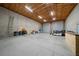 Large, unfinished garage with concrete floor, exposed wood ceiling and block walls ready for customization at 11707 Se 101St Court Rd, Belleview, FL 34420