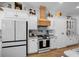 Bright kitchen featuring white cabinetry, stainless steel appliances, and a custom wooden range hood at 11707 Se 101St Court Rd, Belleview, FL 34420