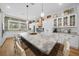 Open kitchen concept featuring a large island, white cabinets, stainless appliances, and wood accent wall at 11707 Se 101St Court Rd, Belleview, FL 34420