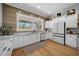 Kitchen with a large window, white cabinetry, stainless steel appliances, and wood accent wall at 11707 Se 101St Court Rd, Belleview, FL 34420