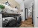 Modern laundry room with brick accents, front loading washer/dryer, and wooden countertop at 11707 Se 101St Court Rd, Belleview, FL 34420