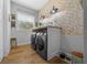 Practical laundry area with new appliances, ample workspace, and natural light, complemented by brick accents at 11707 Se 101St Court Rd, Belleview, FL 34420