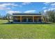 Expansive covered patio featuring wood columns, and outdoor dining and seating areas at 11707 Se 101St Court Rd, Belleview, FL 34420