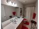 Traditional bathroom featuring a white countertop, cherry cabinets, and bright red accents at 14191 Sw 115Th Ter, Dunnellon, FL 34432