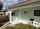 Inviting front porch with white railing and green accents, adorned with a decorative sun at 14191 Sw 115Th Ter, Dunnellon, FL 34432