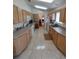 Well-lit kitchen featuring light wood cabinets, ample counter space, and neutral tile flooring at 14191 Sw 115Th Ter, Dunnellon, FL 34432