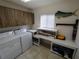 Bright laundry room with a washer, dryer, folding table, and ample storage cabinets at 14191 Sw 115Th Ter, Dunnellon, FL 34432