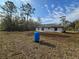 Back view of the property showcasing the yard and outdoor water filter at 15 Locust Trak, Ocala, FL 34472