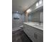Bathroom showcasing a dual sink vanity with gray wood-look floors and tiled shower at 15 Locust Trak, Ocala, FL 34472
