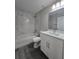 Bright bathroom featuring white marble-style tile, a tub-shower combo and a white vanity with modern fixtures at 15 Locust Trak, Ocala, FL 34472