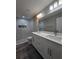 Bathroom showcasing a dual sink vanity with gray wood-look floors and tiled shower at 15 Locust Trak, Ocala, FL 34472