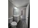 This bathroom offers a white vanity, gray walls, and wood-look flooring, with an open doorway for a bright feel at 15 Locust Trak, Ocala, FL 34472