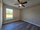 A bedroom with a ceiling fan, a window with outside views, neutral paint and wood-look floors at 15 Locust Trak, Ocala, FL 34472