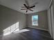 Bedroom with gray walls, gray wood-look floors, a ceiling fan, and a window at 15 Locust Trak, Ocala, FL 34472