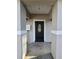 Close up view of the front door, showing the dark door, concrete walkway, and the porch area at 15 Locust Trak, Ocala, FL 34472