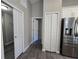 Hallway view to closet and kitchen featuring stainless steel refrigerator at 15 Locust Trak, Ocala, FL 34472