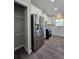 Bright kitchen with stainless steel refrigerator, white cabinets, and gray wood-look flooring at 15 Locust Trak, Ocala, FL 34472