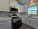 Modern kitchen featuring stainless steel appliances, white cabinetry, and light countertops at 15 Locust Trak, Ocala, FL 34472