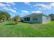 Green backyard with a view of a screened-in porch and blue sky at 15092 Sw 14Th Avenue Rd, Ocala, FL 34473