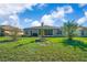 Wide view of backyard with mature trees and landscaping, covered porch, and ample green space at 15092 Sw 14Th Avenue Rd, Ocala, FL 34473