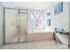 Bright bathroom featuring a soaking tub, neutral tile, glass shower, and complementary decor at 15092 Sw 14Th Avenue Rd, Ocala, FL 34473