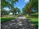 Picturesque entrance to the community featuring a brick-paved road lined with mature trees and landscaping at 15092 Sw 14Th Avenue Rd, Ocala, FL 34473