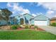 Charming single-story home with a well-manicured lawn, colorful flower beds, and a bright yellow front door at 15092 Sw 14Th Avenue Rd, Ocala, FL 34473