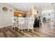 Kitchen with Breakfast Bar: Features white stools, wood cabinets, modern appliances, and wood-look floors at 15092 Sw 14Th Avenue Rd, Ocala, FL 34473