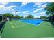 Outdoor tennis courts with green and blue surfaces, surrounded by fencing and trees in a community setting at 15092 Sw 14Th Avenue Rd, Ocala, FL 34473