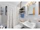 Clean and functional bathroom features a toilet, sink, and shower with a patterned curtain at 1533 Pine St, Apopka, FL 32703