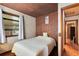 Cozy bedroom with wood paneling, floral wallpaper, and a comfortable bed near the window at 1533 Pine St, Apopka, FL 32703