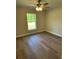 Bright bedroom features wood-look floors, a ceiling fan, and a window with a view of the lawn at 2722 Sw 151St Ave, Ocala, FL 34481