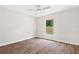 Bedroom with wood-look floors, ceiling fan, and a window overlooking the outdoors at 2722 Sw 151St Ave, Ocala, FL 34481