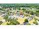 Aerial view of a green house in a suburban neighborhood, surrounded by lush trees and well-kept lawns at 2735 Se 19Th Ct, Ocala, FL 34471