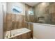 Bathroom featuring a bathtub with elegant tile surround, glass partition, and modern fixtures at 2735 Se 19Th Ct, Ocala, FL 34471