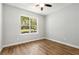 Bright bedroom featuring hardwood floors, a ceiling fan, and a large window with a beautiful outdoor view at 2735 Se 19Th Ct, Ocala, FL 34471