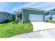Side view of a green home, focusing on the garage and the neatly kept front yard at 2735 Se 19Th Ct, Ocala, FL 34471