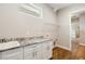 Laundry room with granite counters, sink, shelving and wood flooring at 2735 Se 19Th Ct, Ocala, FL 34471