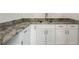 Wet bar area featuring custom cabinets, stone countertops, and brushed nickel faucet at 2735 Se 19Th Ct, Ocala, FL 34471