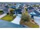 Aerial view of a well-manicured property featuring lush landscaping and a long driveway surrounded by neighboring homes at 3407 Melbourne Ln, The Villages, FL 32163