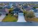 Aerial view of a beautifully landscaped home with a long driveway and mature trees in a suburban neighborhood at 3407 Melbourne Ln, The Villages, FL 32163