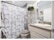 Well-lit bathroom with a modern shower curtain, vanity, and shelving for a clean, fresh look at 3407 Melbourne Ln, The Villages, FL 32163