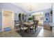 Open concept dining room with vaulted ceilings featuring a dining table for six, leading to an adjacent seating area at 3407 Melbourne Ln, The Villages, FL 32163