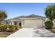 Single-story home featuring an attached two-car garage, well-maintained landscaping, and a welcoming entrance at 3407 Melbourne Ln, The Villages, FL 32163