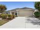 Lovely single-story home featuring an attached two-car garage and a well-maintained front yard with mature landscaping at 3407 Melbourne Ln, The Villages, FL 32163